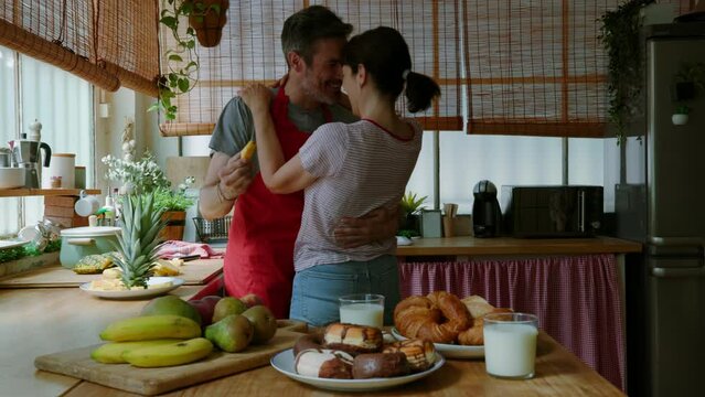 Middle aged couple being flirtatious in kitchen
