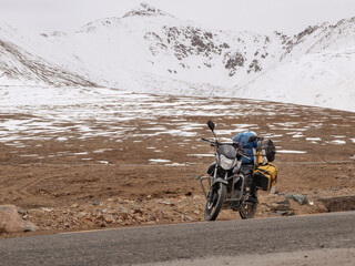 Touring motorcycle and snow covered mountains