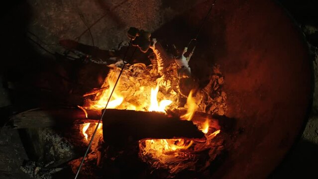 roating mashmallow candy on the firewood heat while camping in autumn winter time