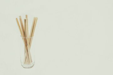 Bamboo straws in a glass against light grey background, perfect for customisation! Add Your Text, Logo, or Graphics to create stunning Presentations