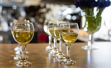 Many glasses of different wine in a row on bar counter