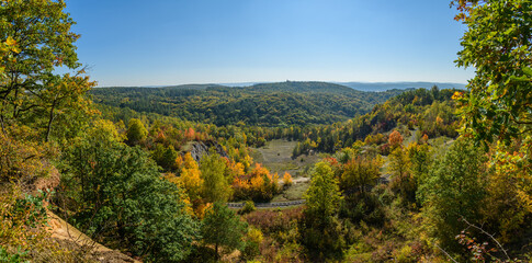view from hill to valley with tracks and forest starting to get autumn colors