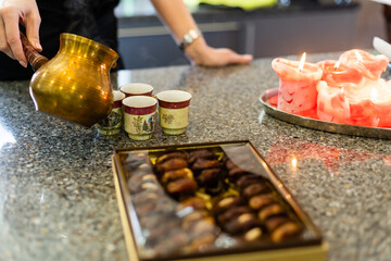 Pouring turkish coffee into vintage cup on wooden background