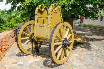 A vintage gun carriage without a gun is exposed to the street