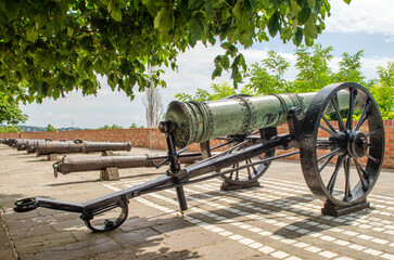 An old cannon on a gun carriage exposed on the street