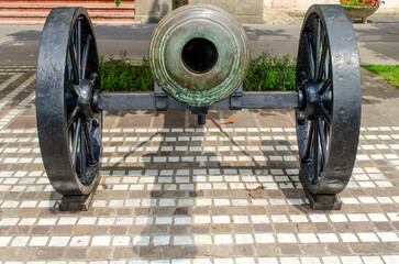 An old cannon on a gun carriage exposed on the street