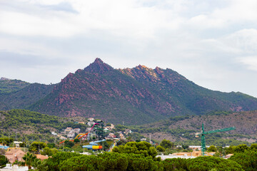 Fototapeta na wymiar Mountains. Desert of Las Palmas seen from the town of Benicasim, in Castellón. Mountainous and rocky system with green trees throughout the rocky extension, in Spain. Europe. Horizontal photography.