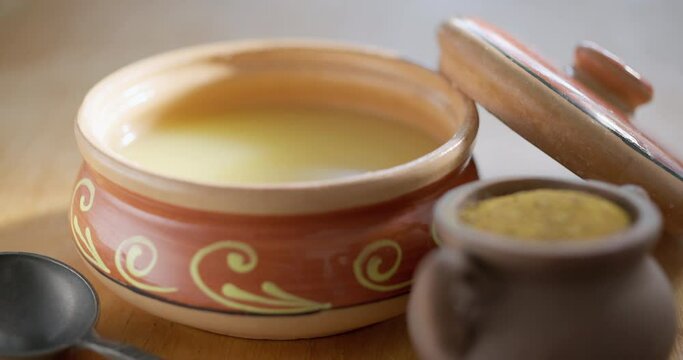 .Pure OR Desi Ghee also known as clarified liquid butter. Pure OR Desi Ghee in ceramic bowls on an old wooden table.