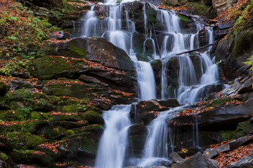 Fototapeta na wymiar Waterfall in a beech forest in autumn. Eastern Carpathians.