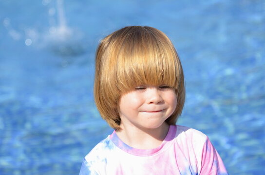 Portrait of a cute little boy on the background of the pool. Summer, family holidays, travel with children. Good mood, going to the water park, amusement park, water attractions, swimming lessons. 