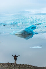 Man jumping in front of a glacier lake