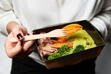 a box of food in the hands of a waiter during catering
