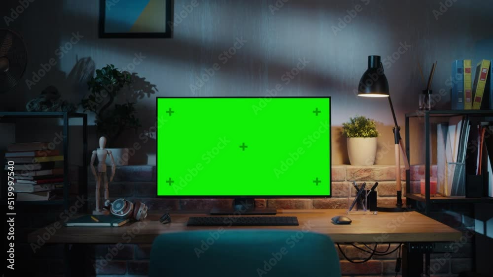 Poster Desktop Computer Monitor with Mock Up Green Screen Standing on a Wooden Desk with Height Adjustable Function. Chroma Key Display at Home in Modern Living Room or Creative Loft Office with Brick Wall.