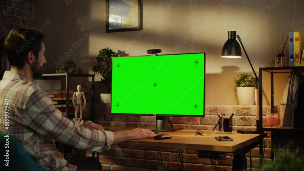 Poster Project Manager Working Remotely from Home, Having a Video Call on Desktop Computer with Monitor with Green Screen Mock Up. Man Sitting in Living Room, Chatting with Business Partners and Clients.