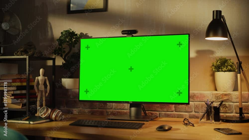 Aufkleber Modern Personal Computer Monitor with Green Screen Mock Up Display Standing on a Desk with Keyboard, Mouse, Smartphone, Notebooks and Headphones. Cozy Home Office in Loft Living Room Space. Arc Shot.