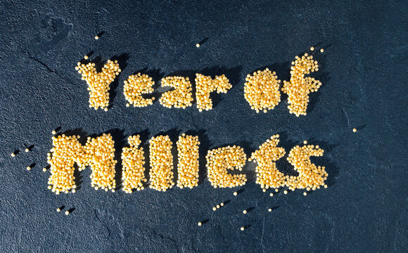 Year of millets text with grain on dark background