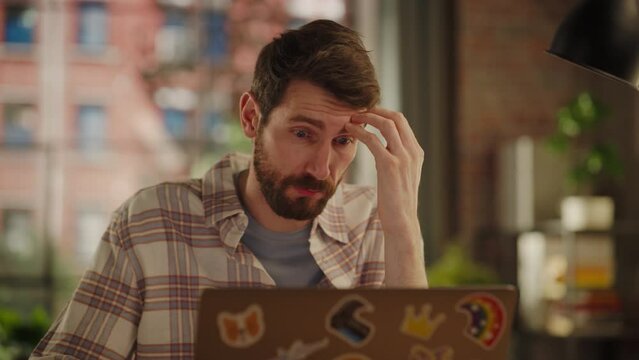 Stressed Worried Man Working from Home, Trying to Fix an Unsuccessful Project Plan Issue. Exhausted Manager Using Laptop Computer in Living Room. Specialist Received Problematic News.