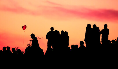Fototapeta premium Silhouettes of people with different expressions on the embankment of the sea sunset.