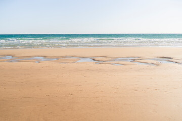 Fototapeta na wymiar playa desierta con huecos de arena llenos de agua