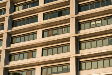 Fototapeta na wymiar Edificio de oficinas con el cielo despejado azul al atardecer con colores dorados