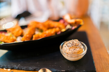 Plato de pollo empanado con guarnición y salsa