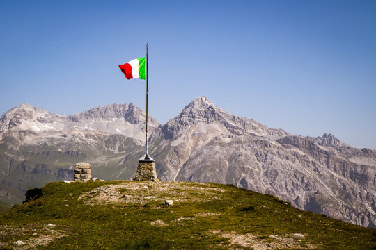 Waving Italian flag in mountain pass (Teurihorn and Alpersch&auml;llihorn in background), Italy
