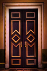 Beautiful gilded door, baroque style, in a gloomy mysterious corridor