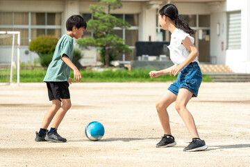 学校でサッカーをしている小学生の子供たち