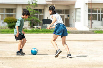 学校でサッカーをしている小学生の子供たち © tatsushi