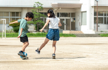 学校でサッカーをしている小学生の子供たち