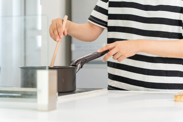 キッチンで料理をしている主婦の女性