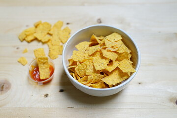 Corn chips in a bowl on a wooden background