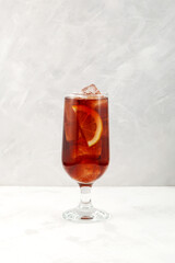 Summer refreshing drink. Iced cocktail red wine based with lemon. Cold drink on grey background.