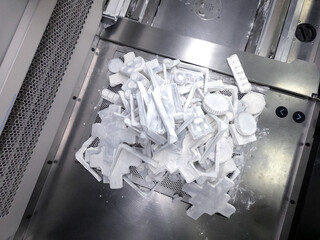 Objects and models printed on industrial 3D printer from white plastic powder in laboratory....