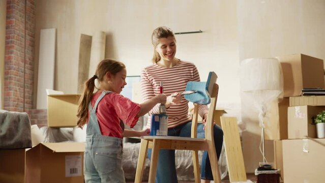Moving in and Home Renovations: Happy Mother Painting Vintage Furniture Chair, Artistic Daughter Runs to Help. Cheerful Young Family Make Apartment Cozy with Art, Color. Following Slow Motion Shot