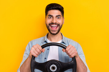 Photo of overjoyed carefree crazy person guy tests new road hold wheel isolated on yellow color...