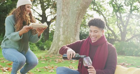 Video of biracial couple warmly having a picnic time in the garden