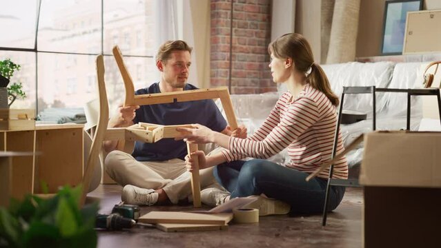 Family Moving in: Happy Couple Assembles Furniture Together, Girlfriend Boyfriend Do High Five after Successfully Doing the Job. Furniture Assembly in New Apartment. Funny Stressful Domestic Situation