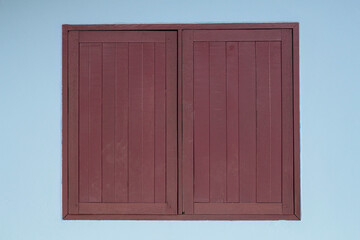 Vintage brown wooden window for homes in the countryside on a  blue cement wall background.