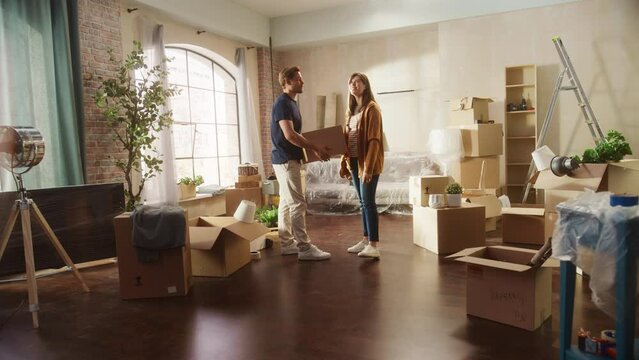 Family New Home Moving in: Happy and Excited Young Couple Enter Newly Purchased Apartment. Beautiful Family Happily Holding Hands. Modern Home Ready for Decorations. Zoom Out Energetic Dynamic Shot