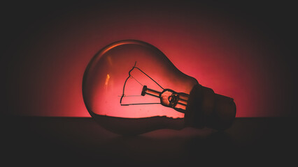 old light bulb glowing with fossil fuel energy which is not renewable creative design template. bulb in red colour can be use to represent red light area