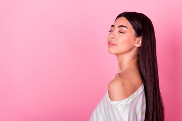 Profile portrait of cute lovely indonesian lady closed eyes empty space isolated on pink color background © deagreez
