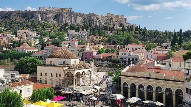 People at the center of Athens visiting the local stores against the Acropolis. 