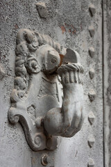 Fototapeta na wymiar Beautiful aged stone knocker in the shape of a hand.