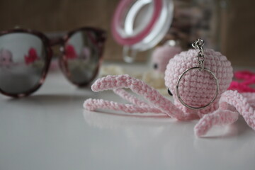 Small toy on a white background. Knitted handmade toys on a white table in the room. Knitting. Hobby. Crochet. Handmade. Content for knitters.