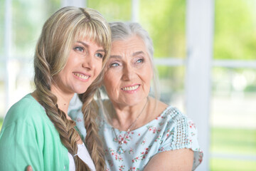 Portrait of senior woman with daughter at home