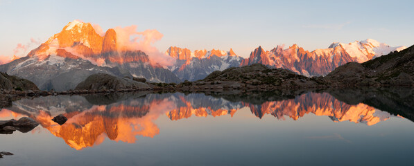 The panorama of Mont Blanc massif  Les Aiguilles towers, Grand Jorasses and Aiguille du Verte over the Lac Blanc lake in the sunset light. - obrazy, fototapety, plakaty