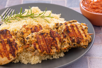 brochettes de poulet grillées et couscous dans une assiette