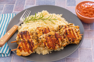 brochettes de poulet grillées et couscous dans une assiette