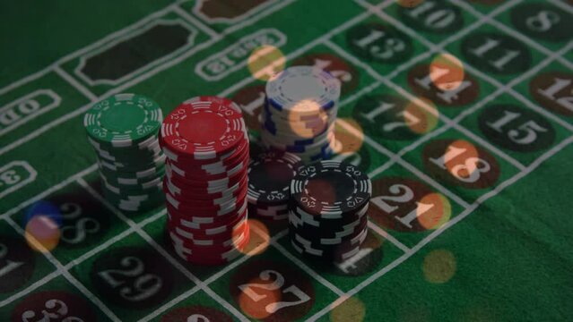 Animation of spots of light over close up of a stack of casino poker chips on a table